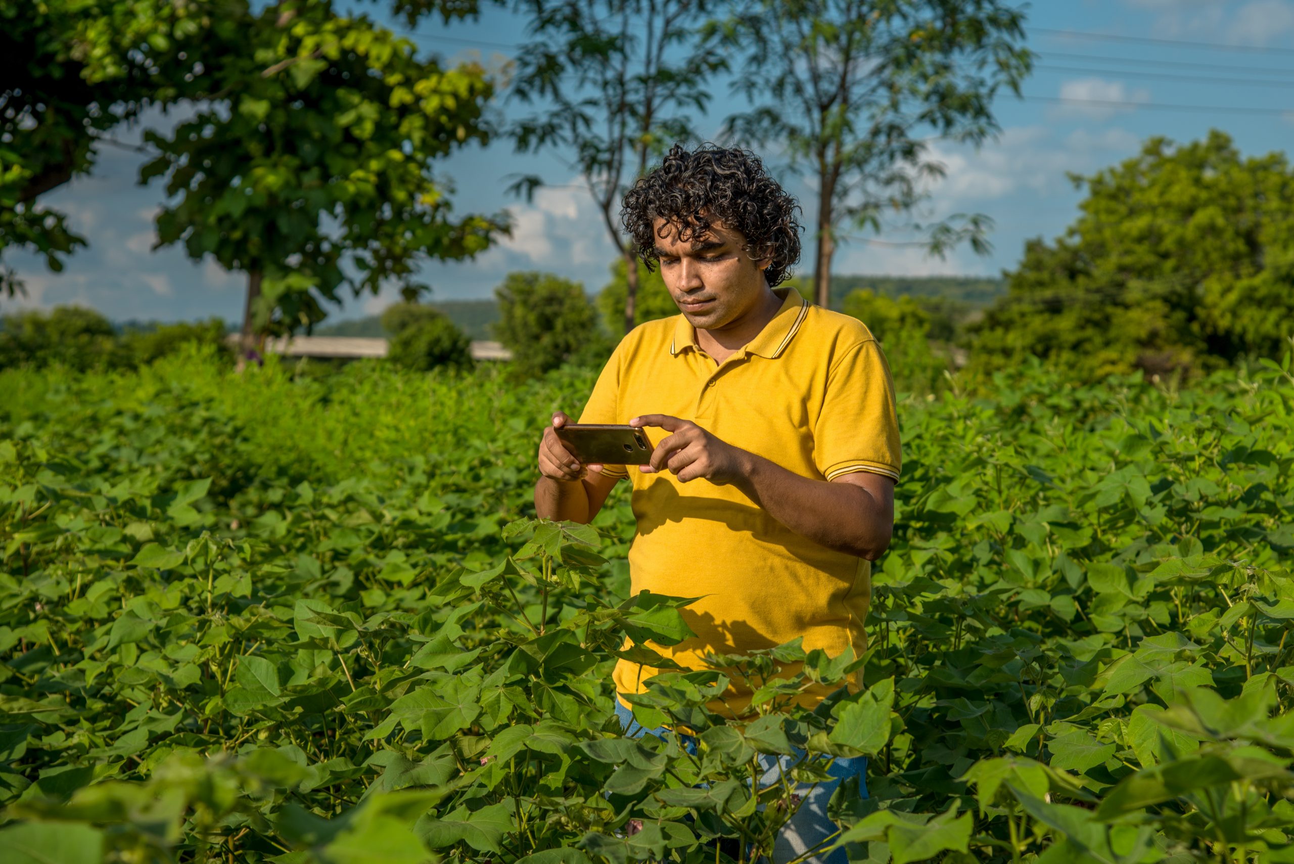 A man holding a phone on a farm